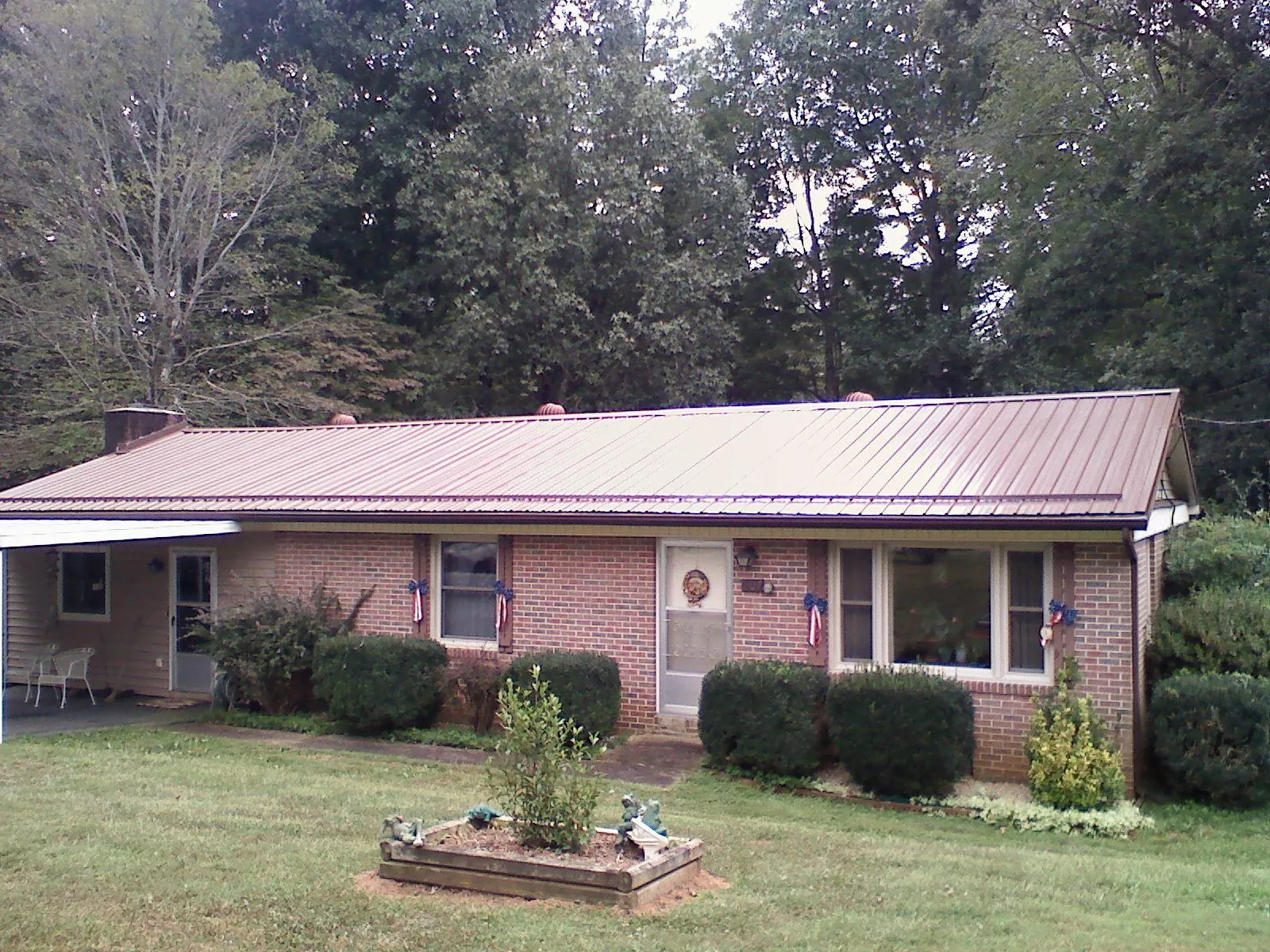 Bronze metal roof on a brick ranch home with a carport in Lakewood