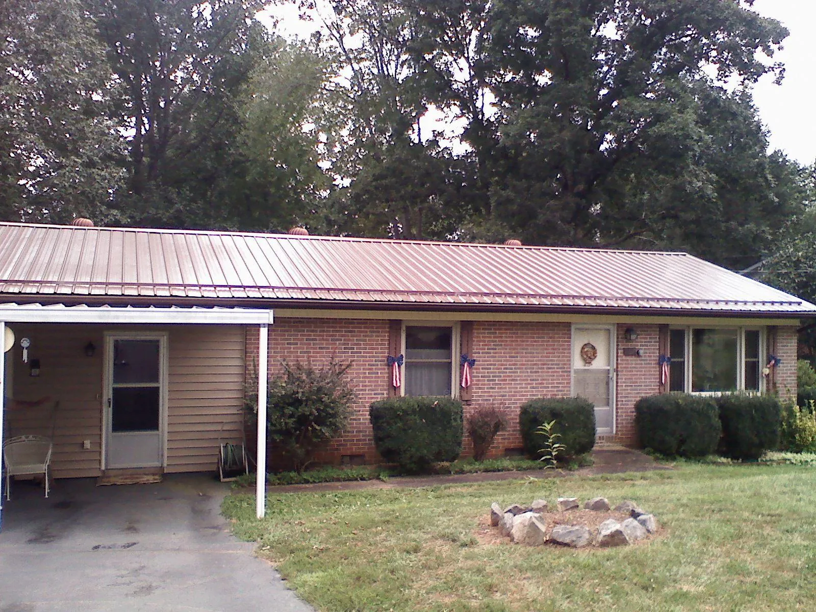 Bronze metal roof and carport on a brick ranch home — Roof Repair work by our crew in Lakewood
